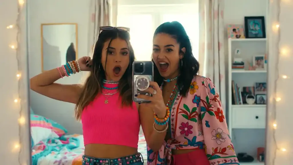 Two stylish best friends taking a mirror selfie and laughing, representing a close bond and fun nicknames.